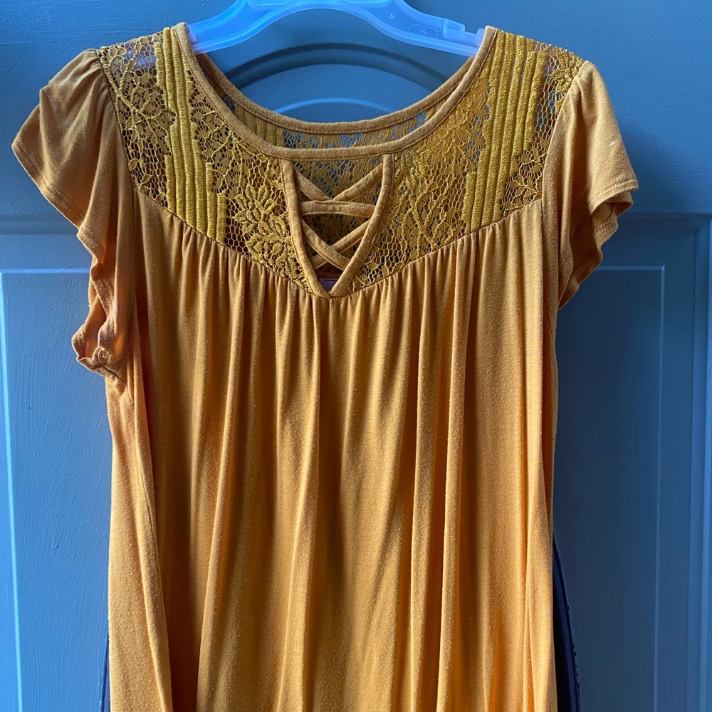 This is an adorable shirt! Gold in color with lace top and top of back